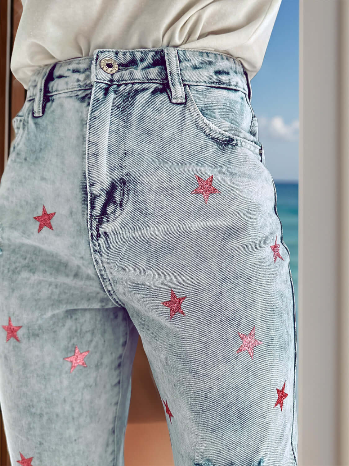 Distressed Star Jeans with pink star detailing and pockets, perfect for a playful and unique look. Made of 65% cotton and 35% polyester.