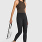 Stylish model in high waist ankle-length black yoga leggings and a brown top, ready for a workout.