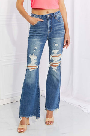 Woman wearing Hazel High Rise Distressed Flare Jeans in blue with frayed hem, featuring high waist, distressed details, and stretchy fabric.