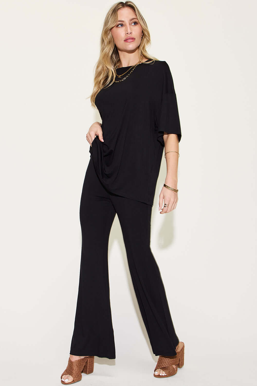 Woman wearing black Bamboo Drop Shoulder T-Shirt and Flare Pants Set with brown heels.