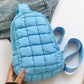 Trendy blue quilted nylon crossbody bag on a casual outfit background, perfect for stylish adventures.