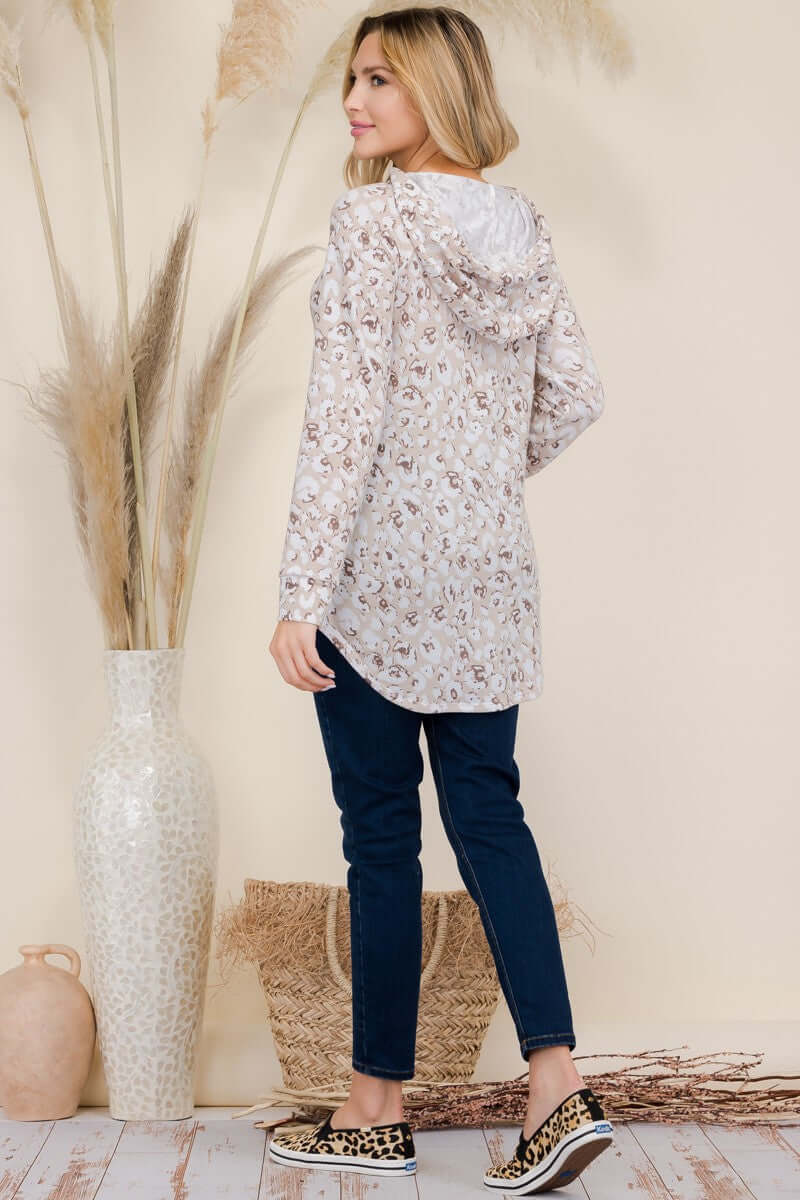 Model showcases Celeste leopard print long sleeve hooded blouse with drawstring detail, styled with casual jeans and sneakers.