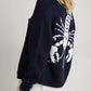 Woman wearing Bella Road Lobster Button Up Long Sleeve Cardigan with playful lobster design on the back.