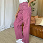 Woman wearing RFM Full Size High Rise Garment Dye Wide Leg Jeans in rose, showcasing high-waist fit and wide-leg silhouette.