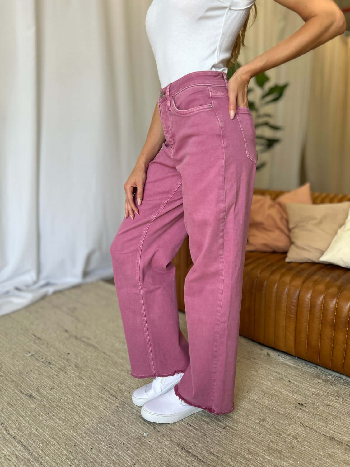 Woman wearing RFM Full Size High Rise Garment Dye Wide Leg Jeans in rose, showcasing high-waist fit and wide-leg silhouette.