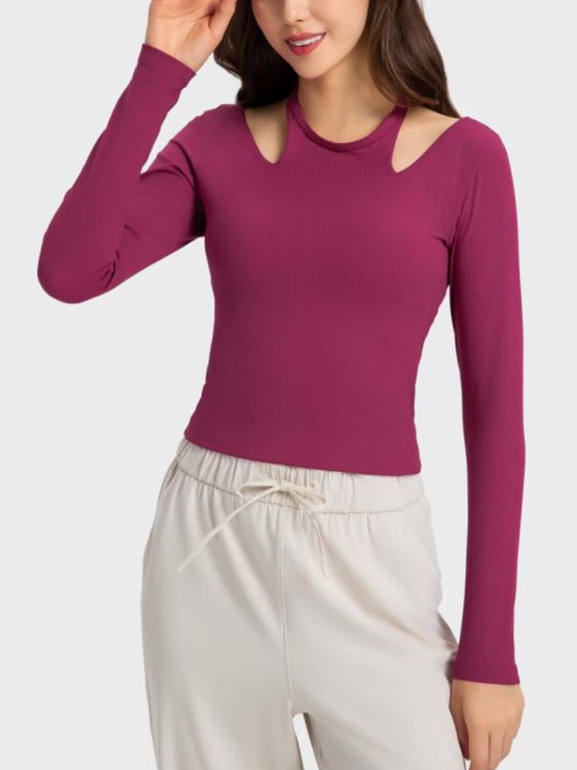 Woman wearing a stylish halter neck long sleeve sporty top in burgundy, perfect for workouts and casual outings.