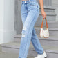 Stylish woman in Bella Road Distressed Jeans with pockets, showcasing an edgy, pocketed look while holding a coffee and purse.