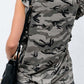 Woman wearing Bella Road Ruffled Printed T-Shirt with camouflage pattern, round neck, and cap sleeves, paired with denim shorts.