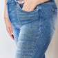 Close-up of a person wearing high rise ankle flare Risen jeans with hand in pocket, showcasing the comfortable fit and quality denim.