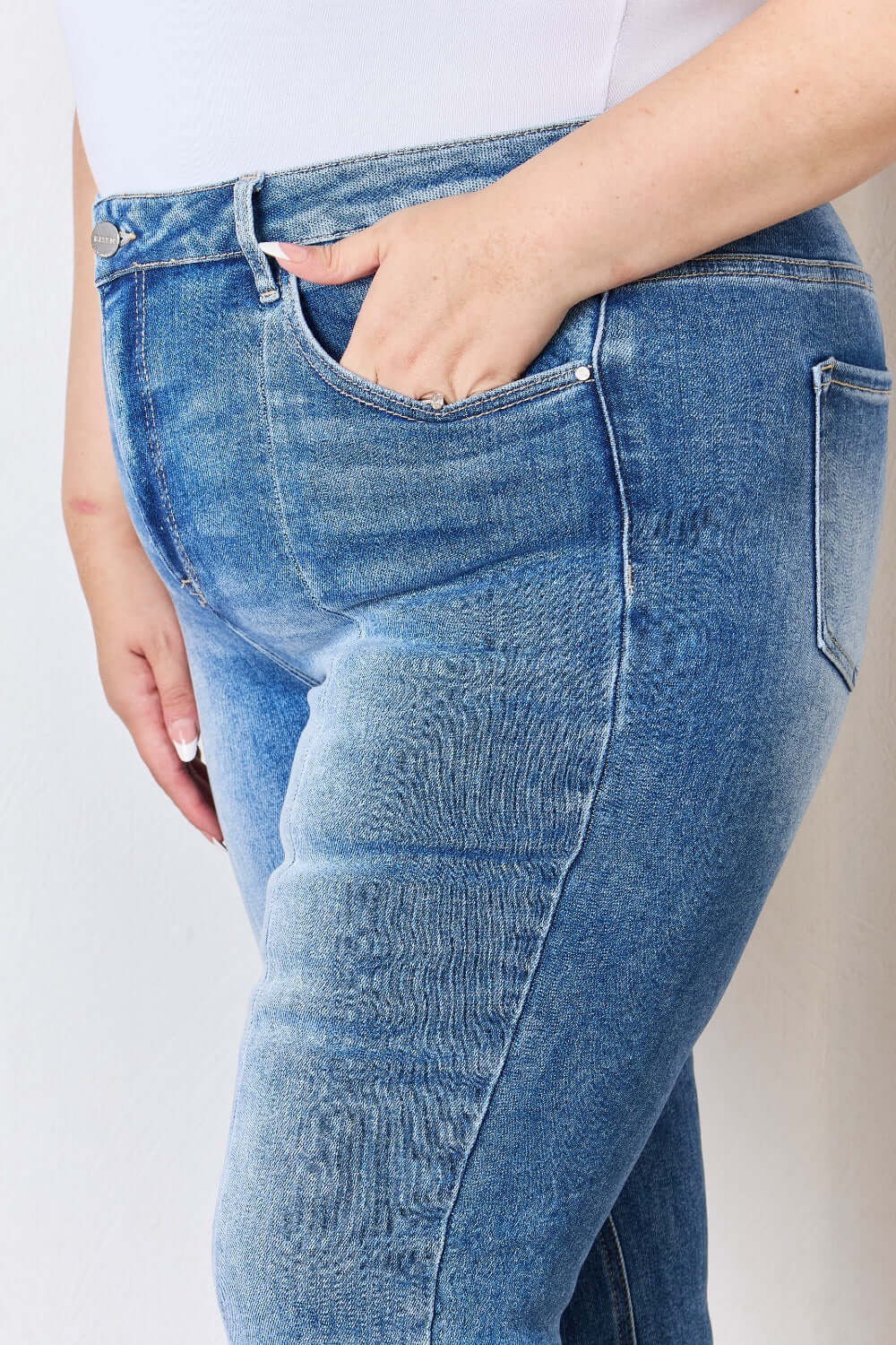 Close-up of a person wearing high rise ankle flare Risen jeans with hand in pocket, showcasing the comfortable fit and quality denim.