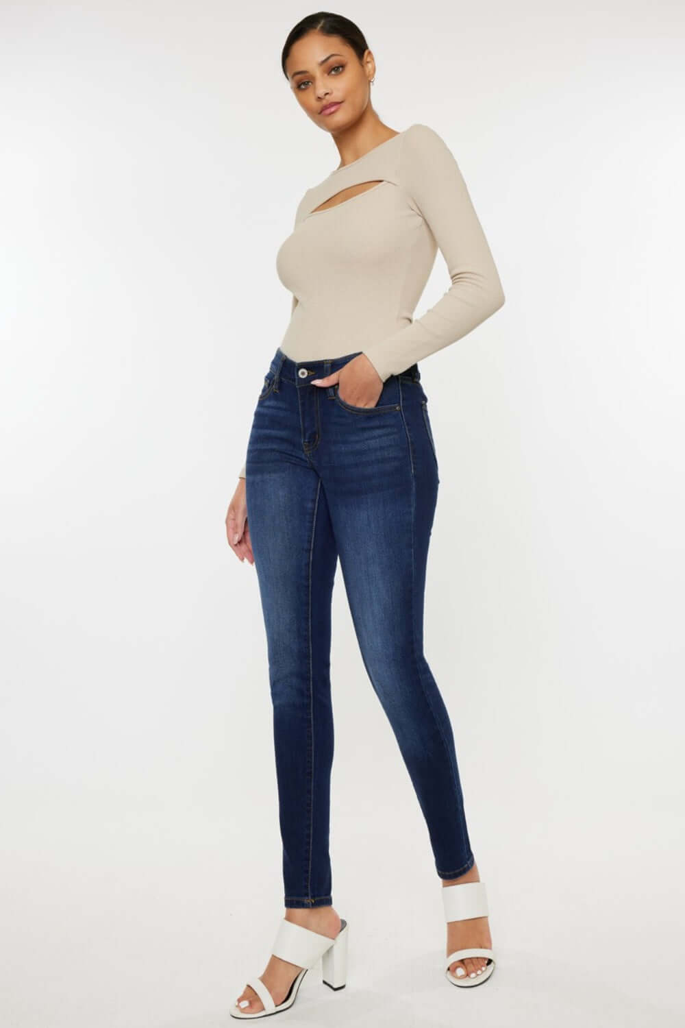 Woman wearing Mid Rise Gradient Skinny Jeans and beige long-sleeve top, showcasing a trendy and stylish look.