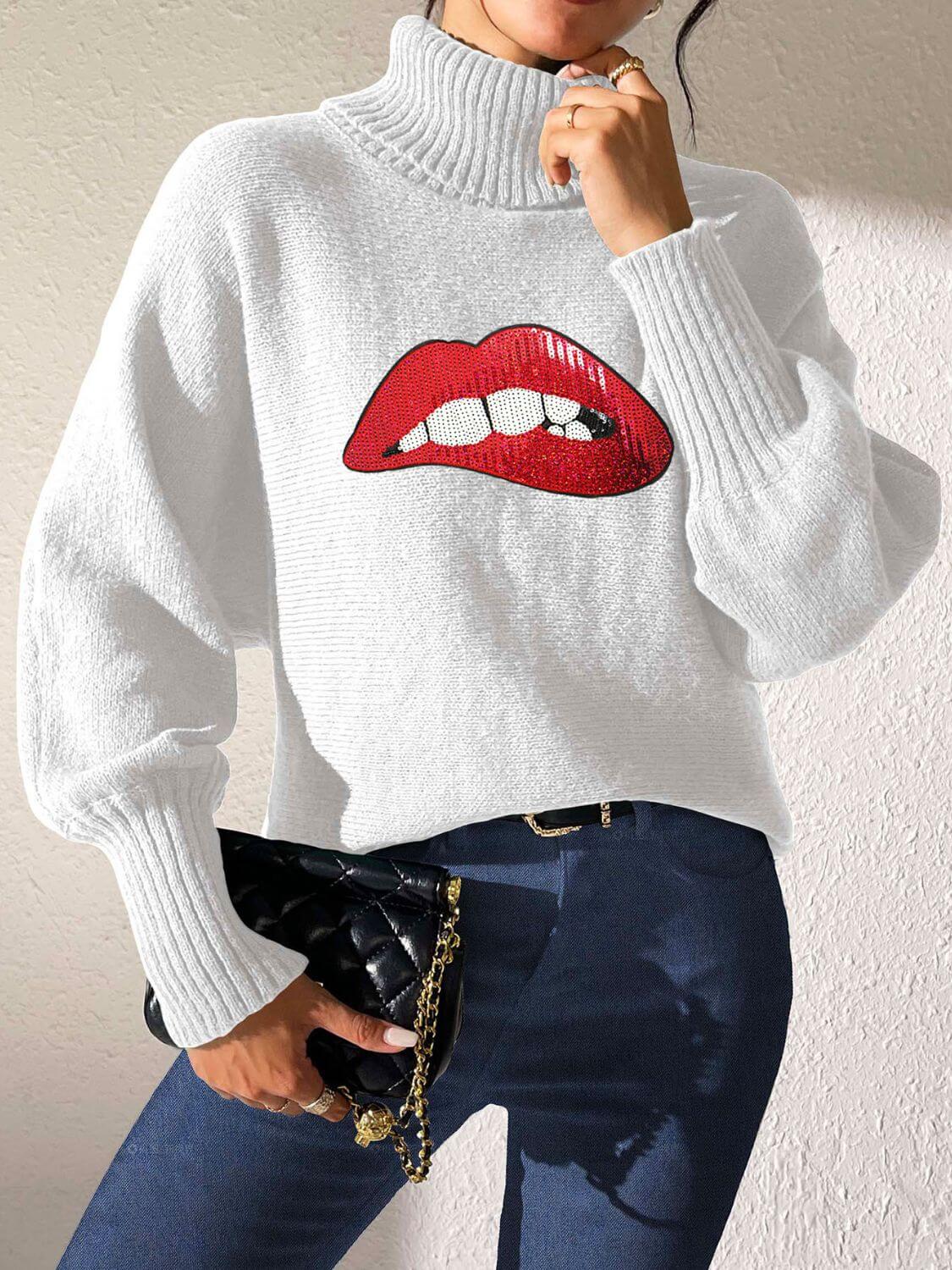 Woman wearing Bella Road Lip Turtleneck Long Sleeve Sweater, featuring red lip design, paired with dark jeans and a black clutch.