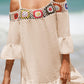 Woman wearing crochet cold shoulder three-quarter sleeve cover up with ruffled hem and multicolor design at beach