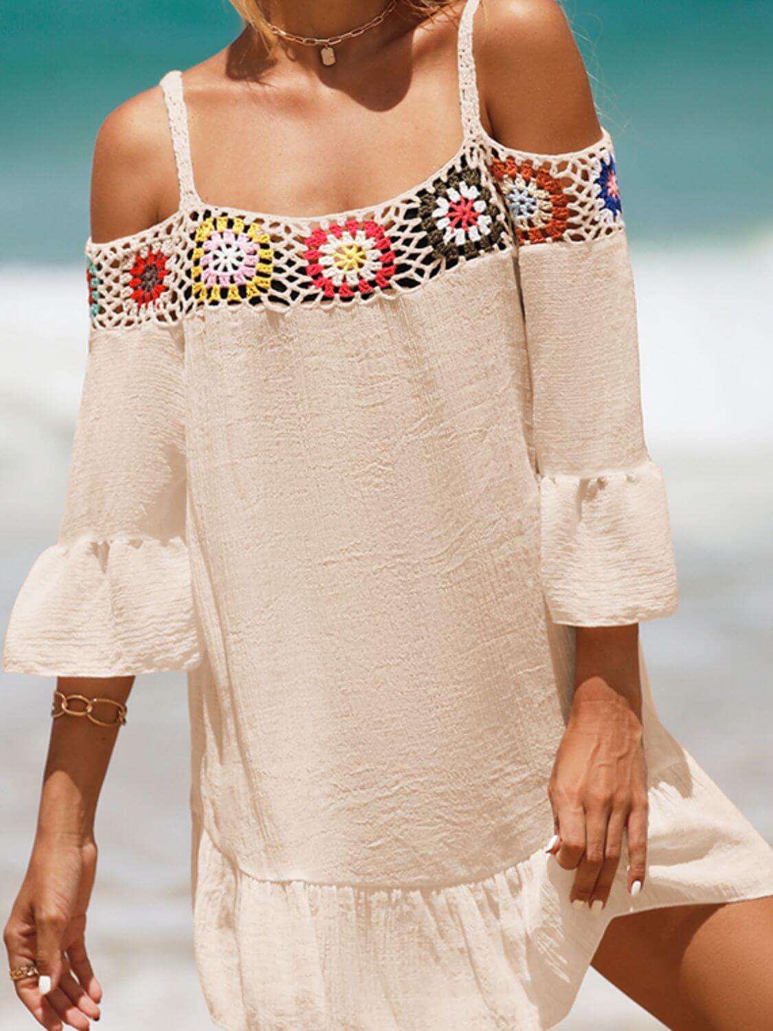 Woman wearing crochet cold shoulder three-quarter sleeve cover up with ruffled hem and multicolor design at beach