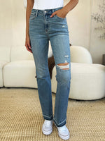 Woman wearing Mid Rise Destroyed Hem Distressed Judy Blue Jeans standing in a casual setting