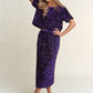 Stylish woman in a dazzling purple sequin outfit, perfect for a night out or casual gathering.