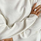 Cozy white turtleneck sweater with side slits and dropped shoulders, perfect for stylish warmth.