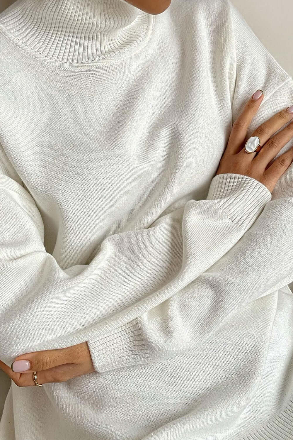 Cozy white turtleneck sweater with side slits and dropped shoulders, perfect for stylish warmth.