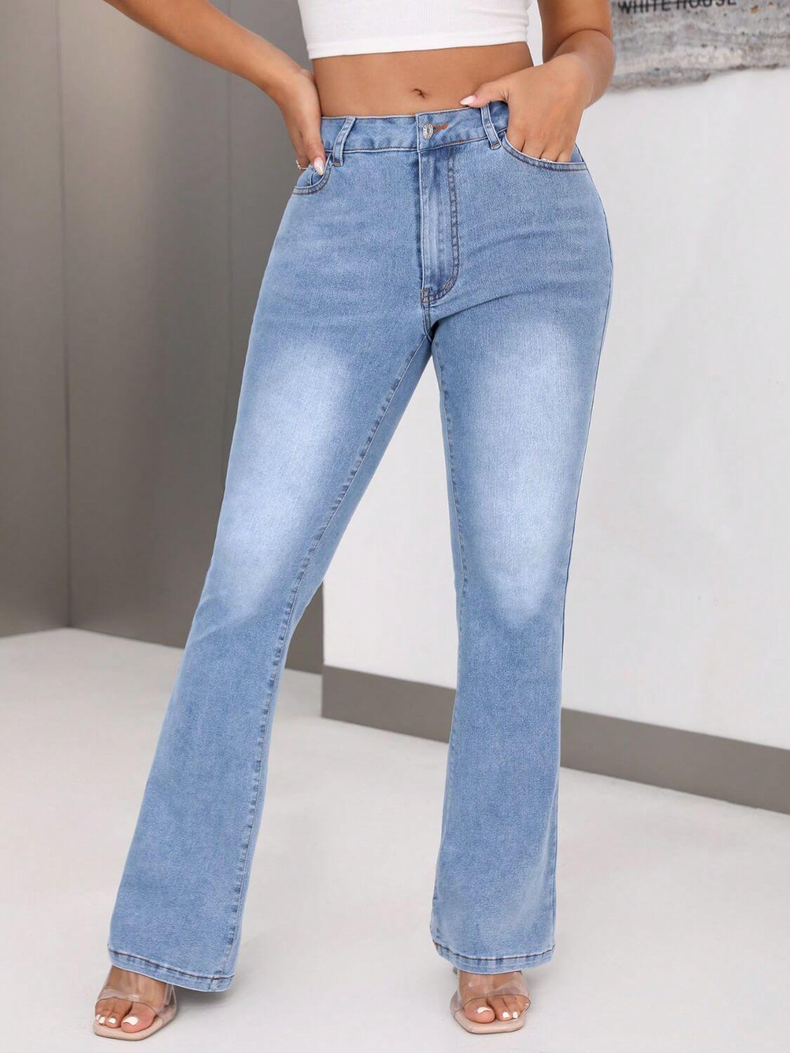 Woman wearing bootcut jeans with pockets and a white crop top