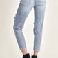 Woman modeling Risen distressed slim cropped jeans, showcasing the flattering fit and stylish distressed details from the back.