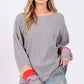 Woman wearing a Color Block Waffle Knit T-Shirt with contrast raglan sleeves and neckline, paired with distressed jeans.