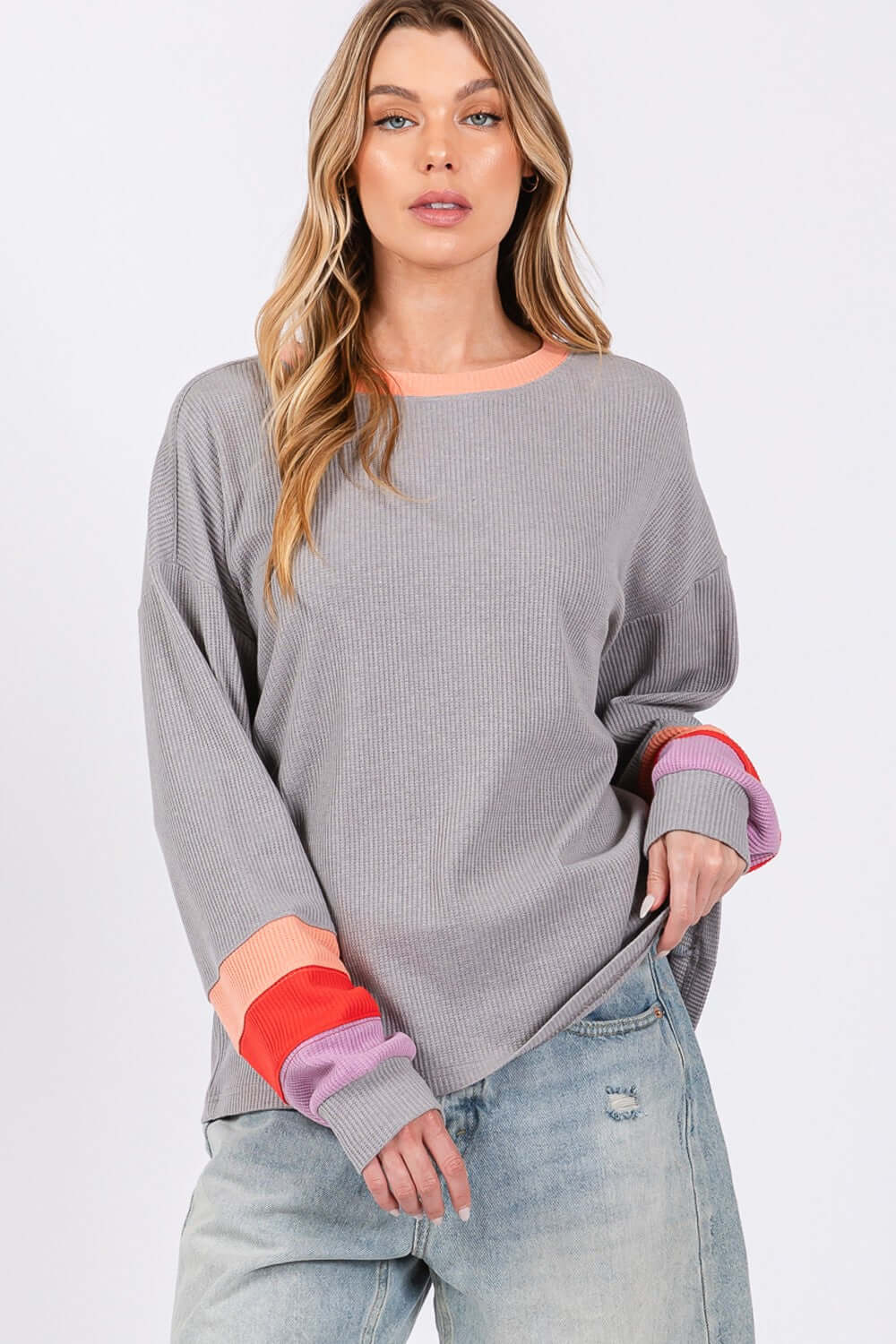 Woman wearing a Color Block Waffle Knit T-Shirt with contrast raglan sleeves and neckline, paired with distressed jeans.