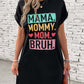 Woman wearing a black letter graphic short sleeve mini tee dress with "Mama Mommy Mom Bruh" text print design.