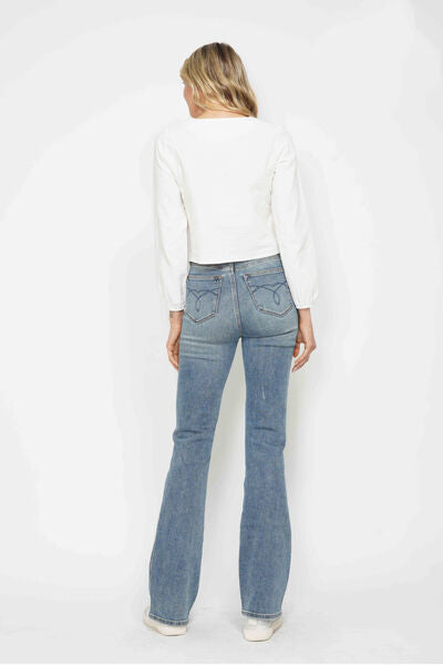 Woman wearing Judy Blue tummy control bootcut jeans with embroidered pockets from the back for a stylish look.