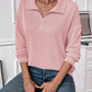 Woman wearing a pink striped half zip long sleeve t-shirt with blue jeans, showcasing a casual and comfortable look.