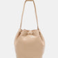 Nicole Lee USA Amy Studded Bucket Bag in beige vegan leather with drawstring closure and metal feet.