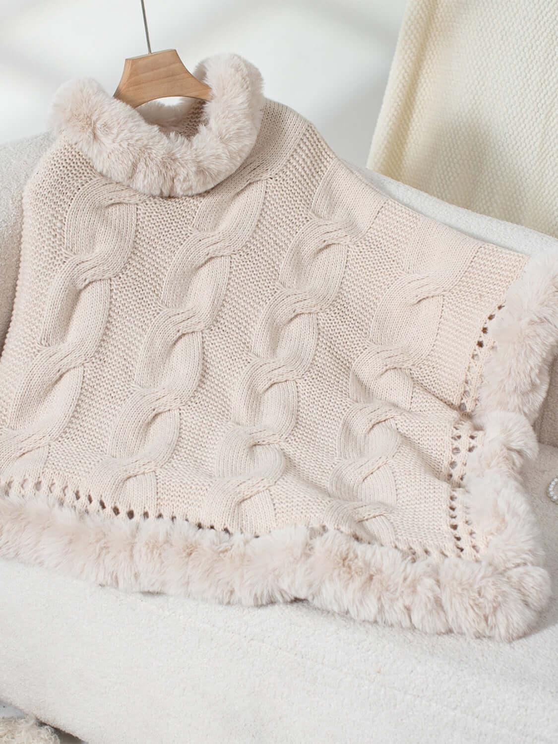 Bella Road Fuzzy Hem Cable-Knit Poncho in soft beige, showcasing cozy cable-knit design and fluffy hem perfect for chilly days.