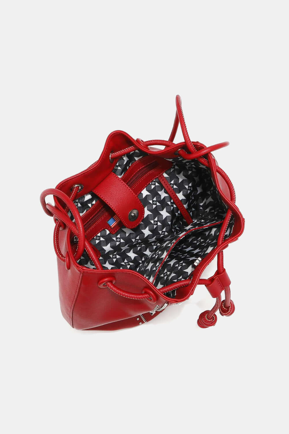 Nicole Lee USA red studded bucket bag with drawstring and snap button closure, showing interior printed polyester lining and zippers.