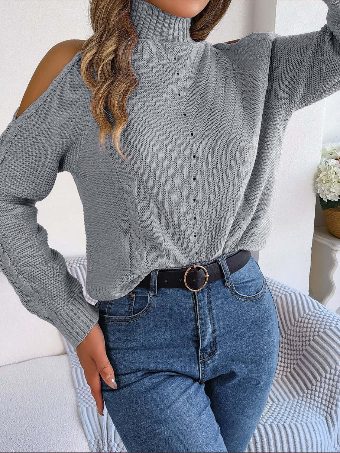 Cozy Bella Road cable-knit turtleneck cold shoulder sweater in gray, paired with jeans for a chic and playful chilly day look.