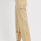 Side view of RISEN high rise wide straight cuffed patch jeans in beige, showcasing relaxed fit and cuffed bottoms.