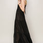 Model showcasing a black halter neck cover-up maxi dress with tiered silhouette and open back, perfect for tropical getaways.