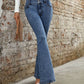 Bella Road bootcut jeans in medium wash, featuring pockets, styled for a chic casual look against a textured wall.