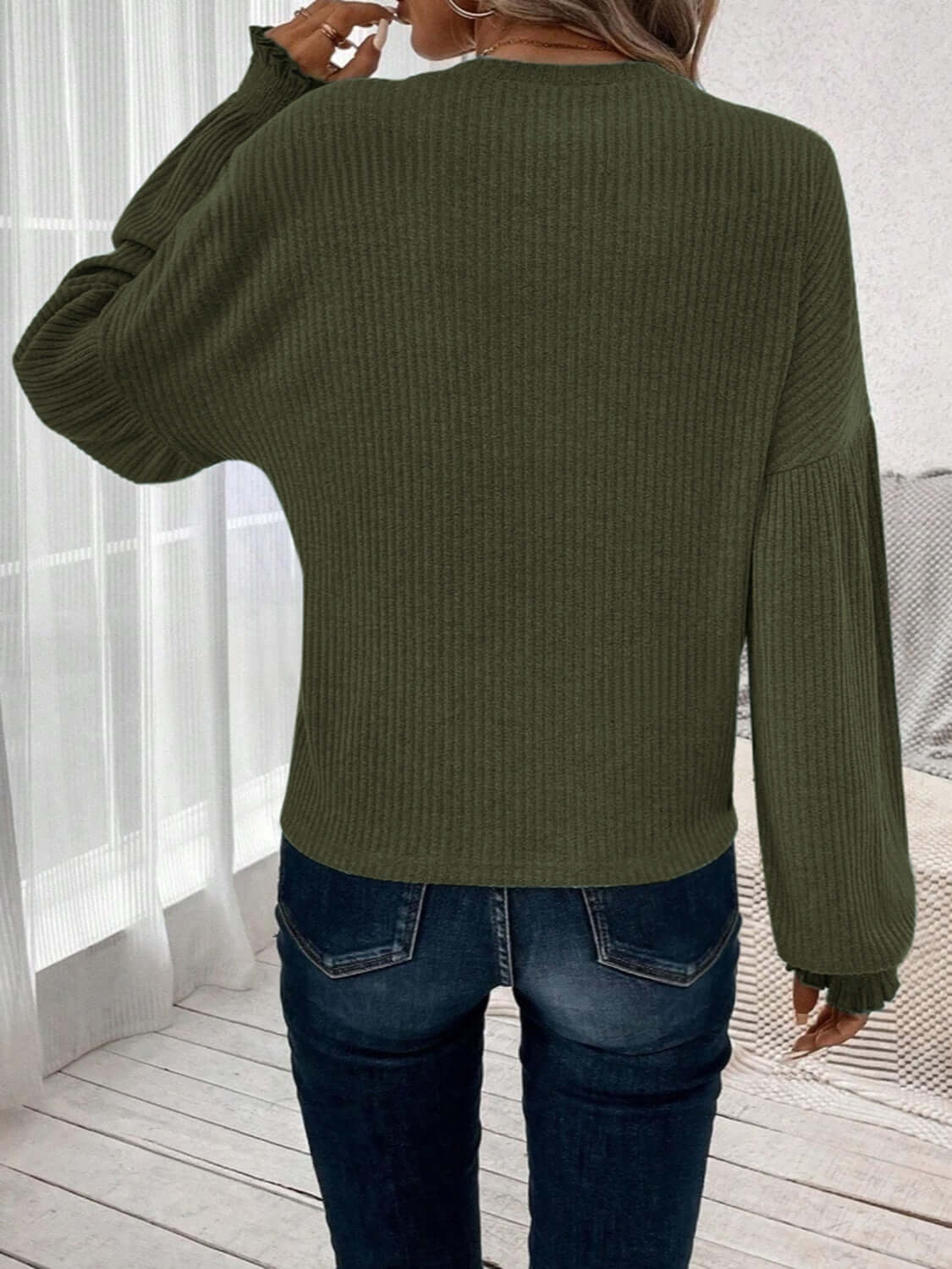 Woman wearing Bella Road Ribbed Round Neck Lantern Sleeve T-Shirt in olive green, showcasing back view indoors.