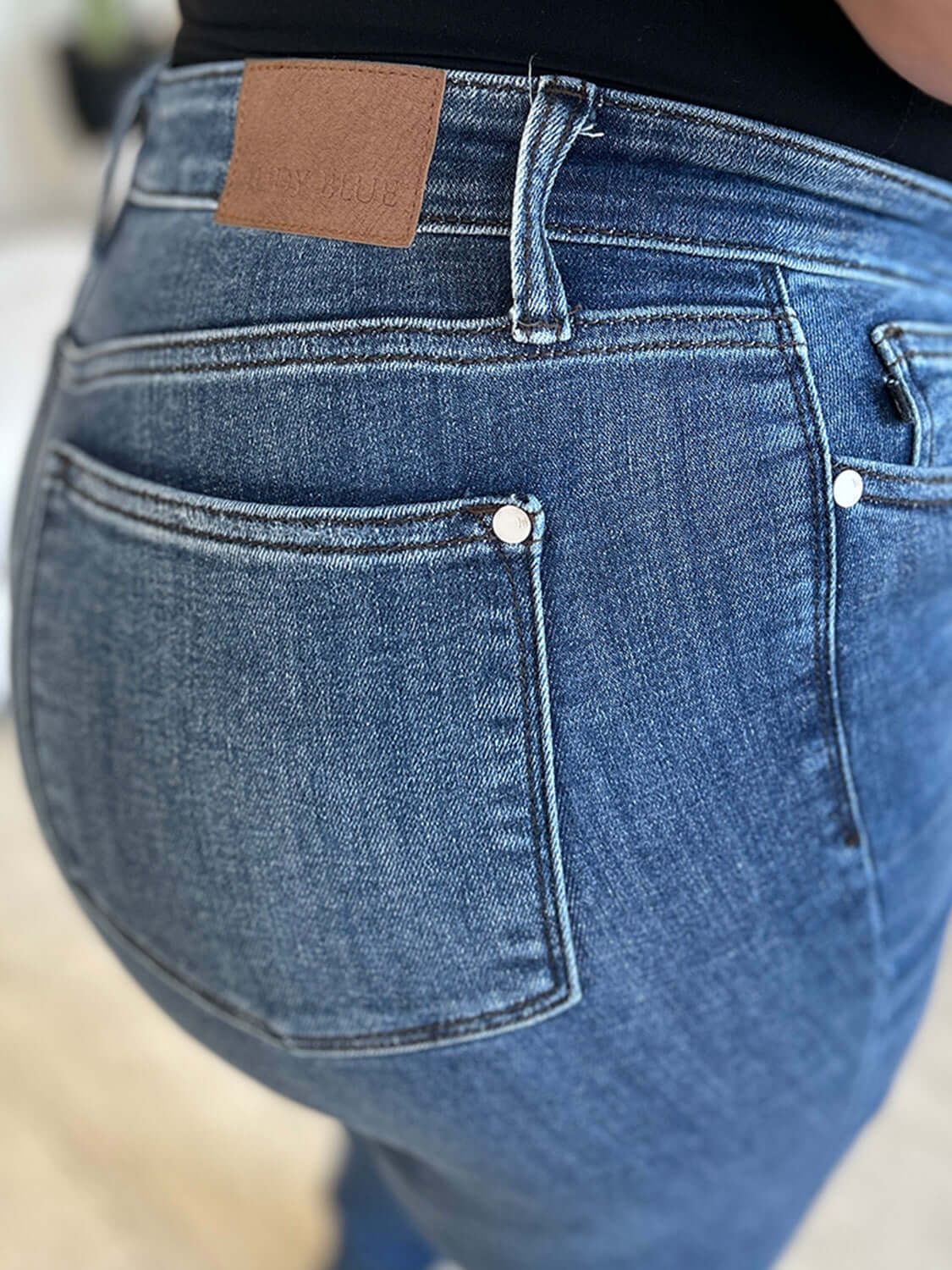 Close-up of High Waist Distressed Skinny Jeans back pocket, showing the details of the Judy Blue Jeans design and denim texture.