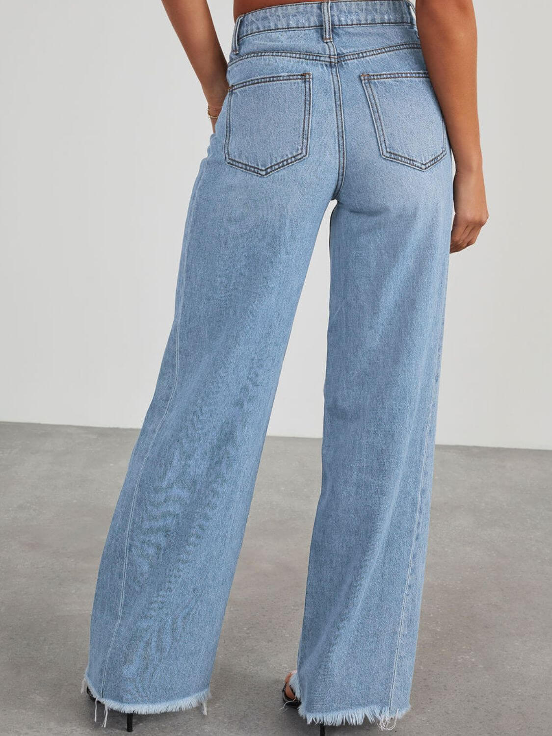 Raw hem wide leg jeans with pockets, back view. Bella Road denim with no stretch, made from 65% cotton and 35% polyester.