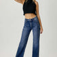 Woman wearing mid rise straight jeans from Risen Jeans, paired with a black crop top, showcasing a stylish and versatile denim look.