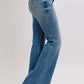 Judy Blue mid rise tummy control vintage wash jeans showcased on model, highlighting flair and flattering silhouette.