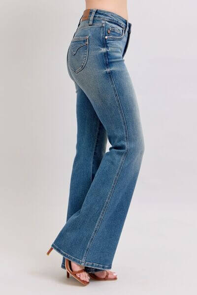 Judy Blue mid rise tummy control vintage wash jeans showcased on model, highlighting flair and flattering silhouette.