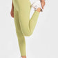 Model stretching in Millennia highly stretchy wide waistband yoga leggings in lemon color, showcasing flexibility and comfort.