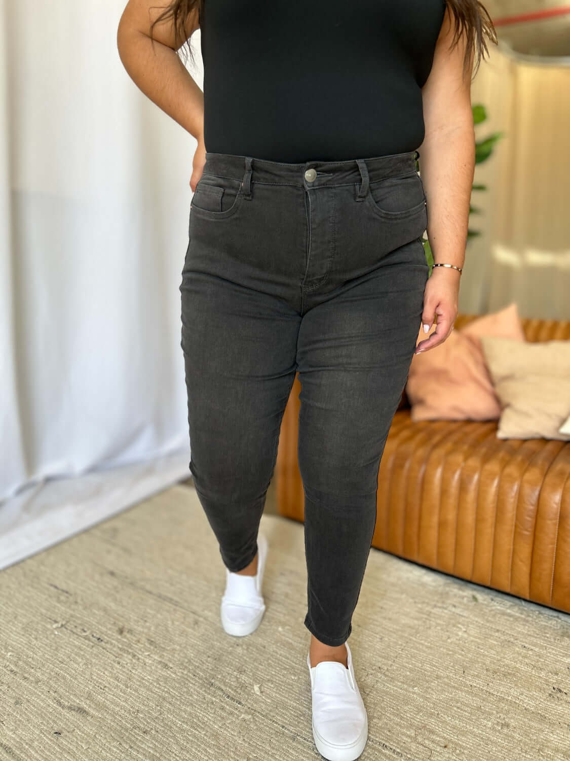 Woman wearing RFM Full Size High Rise Tummy Control Skinny Jeans with a sleek, figure-hugging fit and flattering high-waist design.