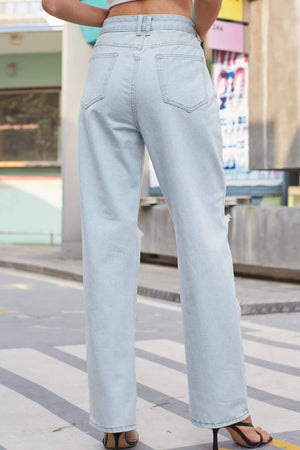 Woman wearing Baeful Distressed Straight Leg Jeans with pockets in light blue, showcasing back view and stylish street style.