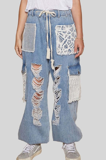 Distressed washed jeans with crochet patches, showcasing a trendy bohemian style perfect for versatile outfits.