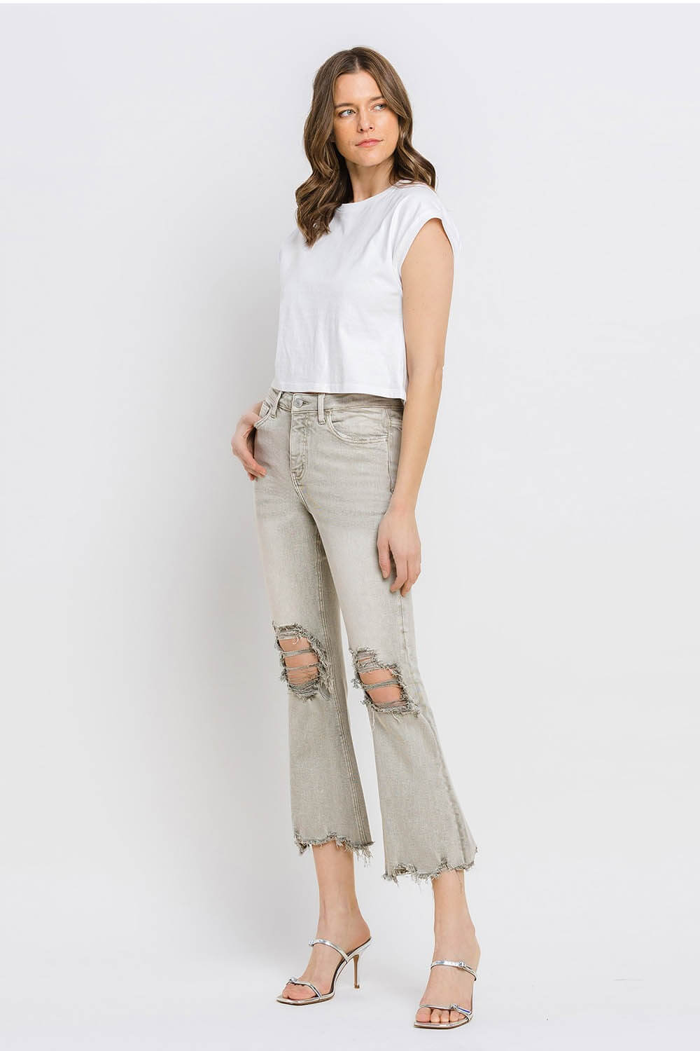 Woman wearing Lovervet distressed raw hem cropped flare jeans with a white tee and heels