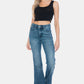 Woman wearing Judy Blue Full Size Tummy Control Cut Hem Flare Jeans with vintage wash, showcasing a stylish and flattering fit.