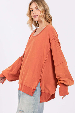 Woman wearing Mineral Wash Side Slit Oversized Sweatshirt with soft fabrication, wide scoop neck, and exposed seaming for a trendy look.