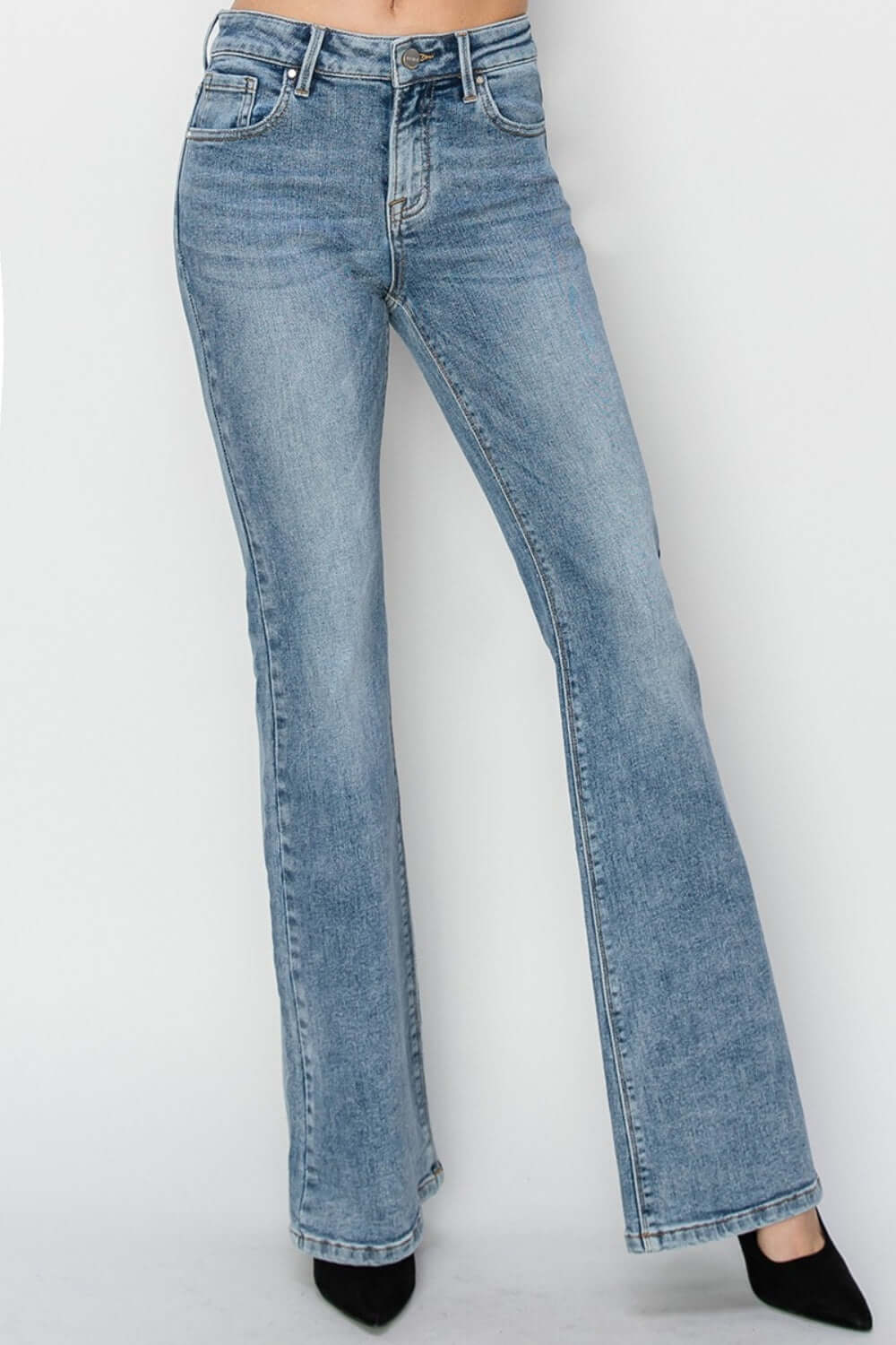 Mid-rise bootcut jeans in classic blue denim by Risen Jeans paired with black heels, showcasing a flattering and versatile silhouette.